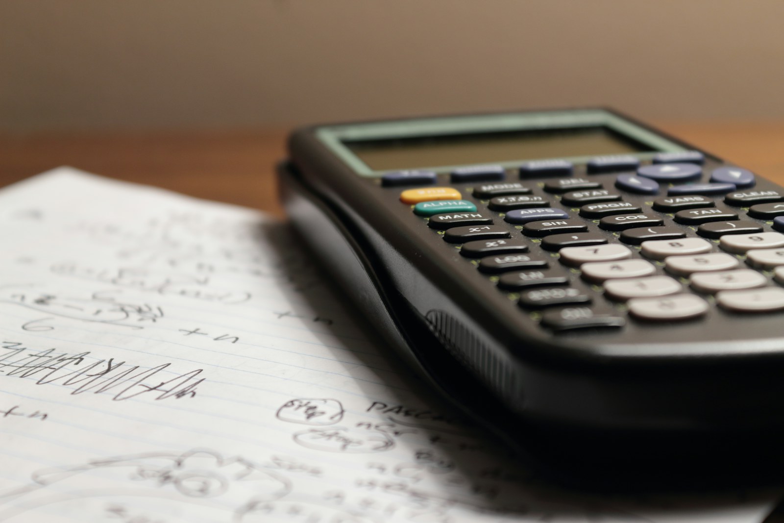 A calculator resting on a notebook with handwritten calculations